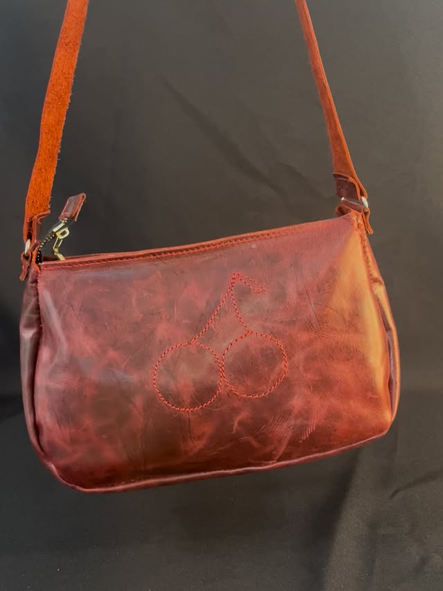 Bolso de piel color rojo con correa